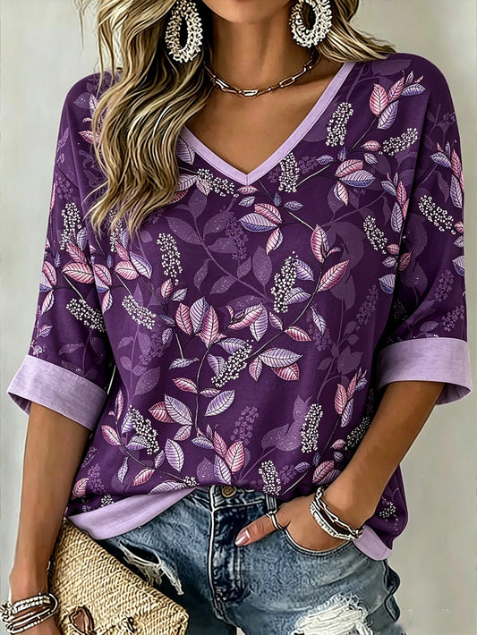 Dammagisk lila t-shirt med tryckt växt- och blommönster, avslappnad modell med halvlånga ärmar och v-ringning